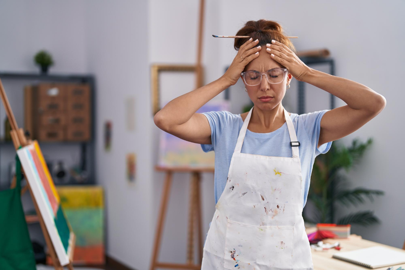 Femme stressée dans un atelier encombré